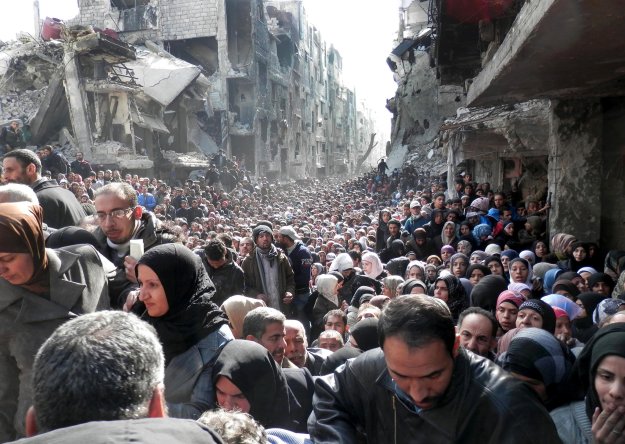 Palestinian refugees in Syria wait for food assistance.